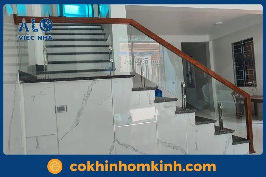 Cầu thang kính gác lửng bậc gỗ sồi gam màu ấm áp