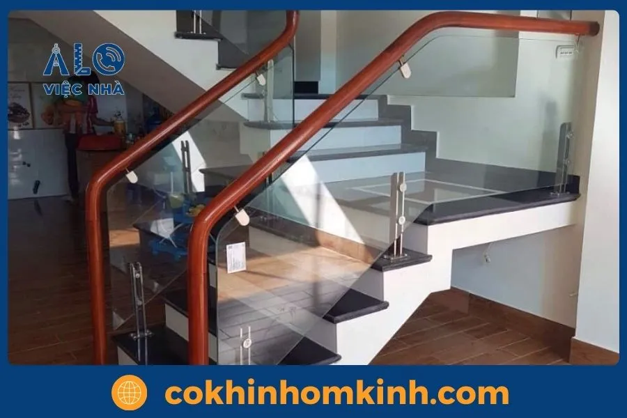 Mẫu cầu thang kính tay vịn gỗ kết hợp trụ inox bền đẹp