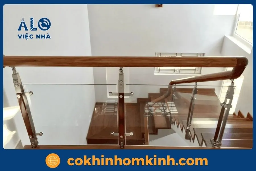 Mẫu cầu thang kính tay vịn gỗ uốn cong mềm mại