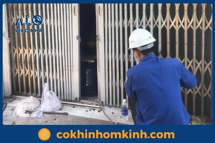 Dịch vụ Sửa Cửa Sắt tại tphcm GIÁ TỐT năm 2026 10 Kỹ thuật viên đang kiểm tra, bôi trơn và bảo trì định kỳ toàn bộ cửa cổng sắt.