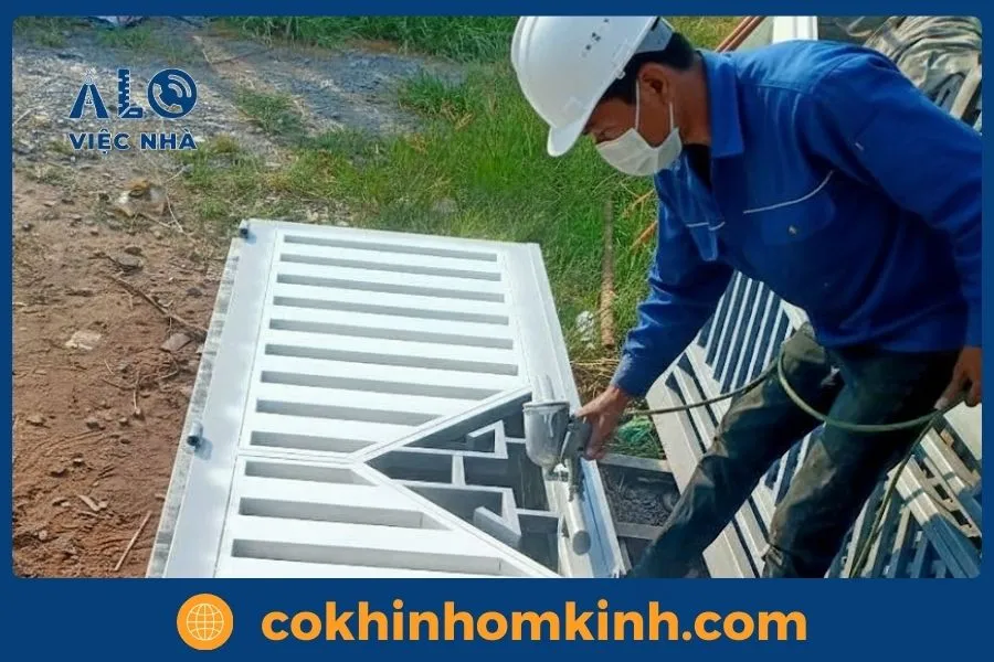 Dịch vụ Sửa Cửa Sắt tại tphcm GIÁ TỐT năm 2026 5 Thợ đang sơn lại cánh cổng cửa sắt