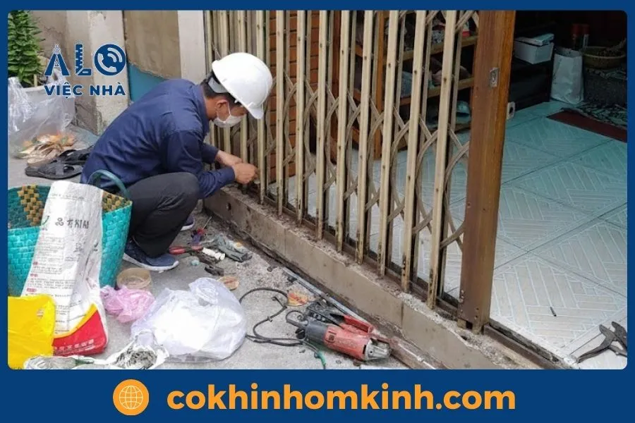 Dịch vụ Sửa Cửa Sắt tại tphcm GIÁ TỐT năm 2026 8 Thợ sửa chữa đang thay thế ray và bánh xe cửa sắt lùa