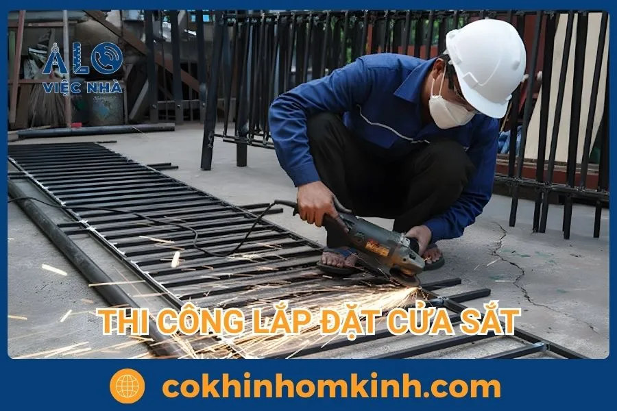 Thợ làm cửa sắt đang cắt sắt với máy cắt cầm tay để lắp đặt cửa sắt tại nhà